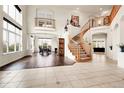 Inviting living room with high ceilings, large windows, wood floors, and a grand staircase at 23965 E Kettle Pl, Aurora, CO 80016