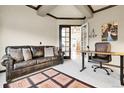 Cozy home office featuring a plush leather couch, desk, and a decorative rug at 23965 E Kettle Pl, Aurora, CO 80016
