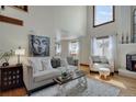 Bright living room featuring hardwood floors, a cozy seating area, and a tall window for ample natural light at 5161 S Emporia Way, Greenwood Village, CO 80111