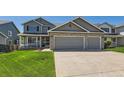 Beautiful two-story gray home featuring a spacious three-car garage and well-kept lawn at 11034 W Aqueduct Ln, Littleton, CO 80127