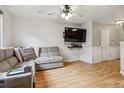 Comfortable living room features wood floors, gray sofa, a mounted television, and a ceiling fan for added convenience at 1953 E 102Nd Cir, Thornton, CO 80229