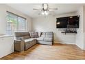 Cozy living room with hardwood floors, a comfortable gray sofa, ceiling fan, and a mounted TV at 1953 E 102Nd Cir, Thornton, CO 80229