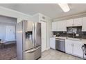 Modern kitchen with stainless steel refrigerator, white cabinets, and gray backsplash at 6800 E Tennessee Ave # 382, Denver, CO 80224