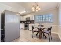 Eat in kitchen featuring stainless steel appliances, a glass dining table, and light tile flooring at 6800 E Tennessee Ave # 382, Denver, CO 80224