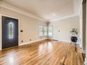 Bright living room with shiny wood floors, a decorative ceiling, and a large window at 5339 S Windermere St, Littleton, CO 80120