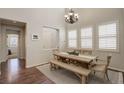 Bright dining room with natural light, chandelier, table with bench and chairs, and hardwood floors at 4542 Valleybrook Dr, Highlands Ranch, CO 80130