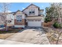 Inviting home showcasing a wide driveway, two-car garage, neutral stucco and stone accents at 4542 Valleybrook Dr, Highlands Ranch, CO 80130