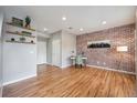 Bright office space featuring brick accent wall, floating shelves and hardwood floors at 4108 W 118Th Pl, Westminster, CO 80031