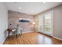 Office with brick accent wall, hardwood floors, and large double doors at 4108 W 118Th Pl, Westminster, CO 80031
