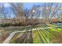 Sunny backyard with mature trees and a paved pathway at 655 S Alton Way # 4B, Denver, CO 80247