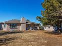 Exterior of a charming ranch-style home with a lush green lawn and mature trees at 2619 Mountain View Ave, Franktown, CO 80116