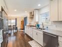Bright, updated kitchen with white cabinetry, subway tile backsplash, and hardwood floors, open to the dining area at 2619 Mountain View Ave, Franktown, CO 80116