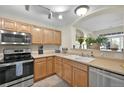 Bright kitchen featuring stainless steel appliances, tile flooring, and seamless access to the dining and living areas at 479 Black Feather Loop # 311, Castle Rock, CO 80104
