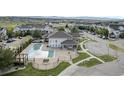 Aerial view of a community pool, clubhouse, manicured green spaces and plenty of parking at 479 Black Feather Loop # 311, Castle Rock, CO 80104