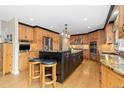 Bright kitchen featuring wooden cabinets, granite countertops, stainless steel appliances, and central island at 930 Reed Ct, Lakewood, CO 80214