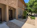 Inviting home entrance with a charming brown door, stone accents, and well-maintained landscaping at 1122 Olympia Ave # 12H, Longmont, CO 80504