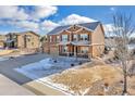 Two-story house with a two-car garage and a partially snow-covered front yard at 1235 Woodmoor Acres Dr, Monument, CO 80132