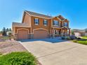A beautiful home boasts a well-maintained lawn and a spacious driveway leading to a three-car garage at 1235 Woodmoor Acres Dr, Monument, CO 80132