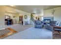 Bright and inviting living room with a stone fireplace and staircase at 1235 Woodmoor Acres Dr, Monument, CO 80132