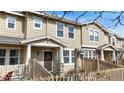 Attractive townhouse exterior featuring well-maintained siding and a fenced-in front yard at 17926 E 104Th Way # C, Commerce City, CO 80022