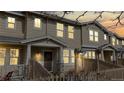 Attractive townhouse exterior with warm lighting, a fenced-in front yard, and welcoming facade at 17926 E 104Th Way # C, Commerce City, CO 80022
