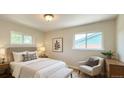 Cozy bedroom with two windows providing natural light and a sitting chair at 8239 Nola Dr, Denver, CO 80221