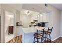 Functional kitchen featuring white cabinetry, a breakfast bar with seating and views to the bathroom at 1830 Newland Ct # 209, Lakewood, CO 80214