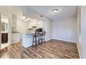 Inviting living space with wood floors, breakfast bar and bar stools leading to the kitchen at 1830 Newland Ct # 209, Lakewood, CO 80214