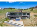 Modern home with sleek lines, a balcony, and a plunge pool that seamlessly integrates with the outdoor living space at 545 Strada Rossa Rd, Golden, CO 80401