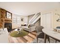 Living room with fireplace, staged furniture, and wood flooring at 1233 S Flower Cir # D, Lakewood, CO 80232