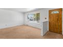 A spacious living room features carpet and a large window offering ample natural light and a view of the outdoors at 6953 Ingalls St, Arvada, CO 80003
