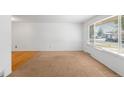 A bright living room featuring new carpet and a large window that floods the space with natural light at 6953 Ingalls St, Arvada, CO 80003