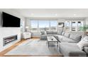 Bright and airy living room with large windows, fireplace, and comfortable seating at 17786 W 86Th Ln, Arvada, CO 80007