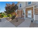Inviting home exterior featuring stone accents, a well-kept lawn, and a welcoming front entrance at 12784 Jasmine St # E, Thornton, CO 80602