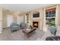 Cozy living room featuring a fireplace with TV, plush seating, large windows, and neutral tones at 12784 Jasmine St # E, Thornton, CO 80602