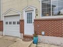 Charming front entrance featuring a brick facade, quaint white door, and a well-maintained garage at 6065 Wadsworth Blvd # A, Arvada, CO 80003