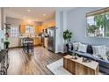 Open-concept living room and kitchen featuring stainless steel appliances, wood floors, and ample natural light at 6065 Wadsworth Blvd # A, Arvada, CO 80003