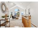 Bright living room featuring vaulted ceilings, large windows, and beautiful views of the surrounding landscape at 1580 Santa Fe Mountain Rd, Evergreen, CO 80439