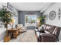 Comfortable sitting room with a leather loveseat, accent chair, decorative accents, and natural light at 19771 E Wesley Pl, Aurora, CO 80013
