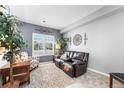 Cozy sitting room featuring a leather loveseat, an accent chair, and natural light from the window at 19771 E Wesley Pl, Aurora, CO 80013