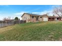 Tan home featuring a paved driveway, two-car garage, and a large front yard at 1882 S Zinnia Way, Lakewood, CO 80228