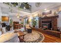 Cozy living room featuring a brick fireplace, wood floors, and bright dining area at 9365 W 80Th Pl # C, Arvada, CO 80005
