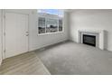 Bright living room features large windows and fireplace with carpet and laminate flooring at 8199 Welby Rd # 1908, Denver, CO 80229