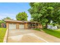 Inviting brick home with an attached two car garage and well-maintained lawn and landscaping at 2876 S Wolff St, Denver, CO 80236