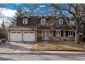 Two-story house with attached two-car garage, landscaping, and a brick facade at 6941 S Poplar Way, Centennial, CO 80112