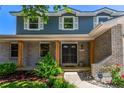 Charming front porch with wooden pillars, a black double door, and landscaped greenery, offering great curb appeal at 5914 S Kearney St, Centennial, CO 80111