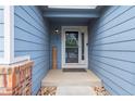Inviting front porch with brick detail and 'Welcome' sign at 1118 S Duquesne Cir, Aurora, CO 80018