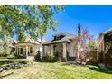 Street view of quaint bungalow featuring a cozy front porch, set amidst a lush green lawn and mature trees at 284 S Lafayette St, Denver, CO 80209