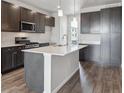 Open kitchen featuring dark cabinetry, stainless steel appliances, and a large island at 453 Interlocken Blvd # 103, Broomfield, CO 80021