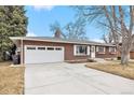 Brick home showcasing an attached garage and concrete driveway at 3276 S Osceola St, Denver, CO 80236